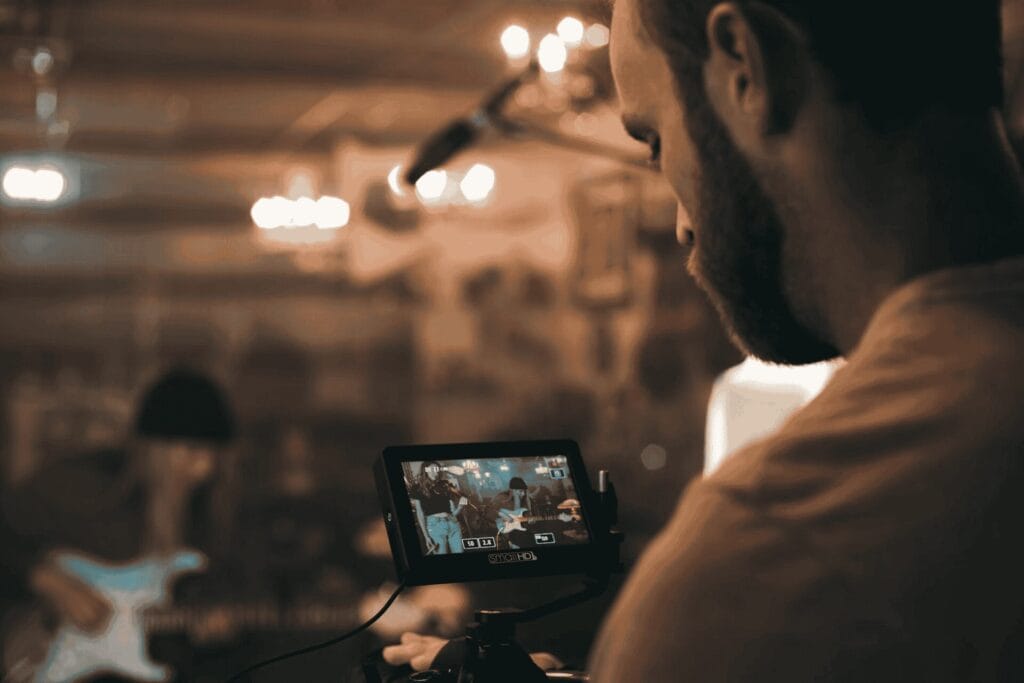 homem segurando câmera de vídeo preta em gravação de video clip